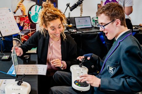 Young person using music technology with a teacher