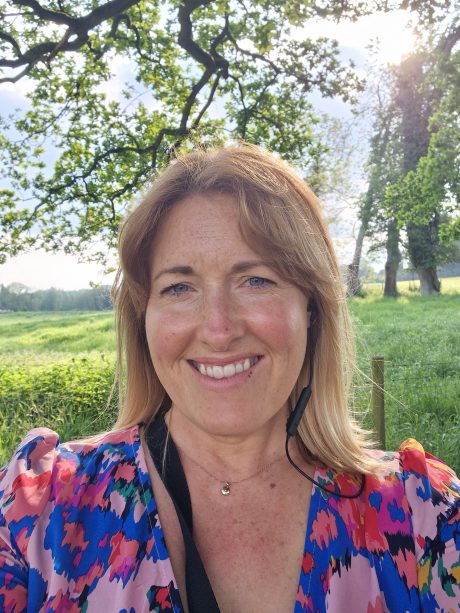 Mia Seymour, smiling at the camera outdoors wearing a colourful blouse