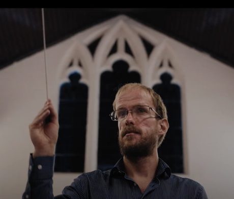 Nathaniel Dye holding a conducting baton