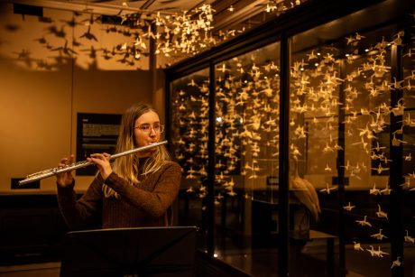 A young woman playing the flute in Manchester Museum